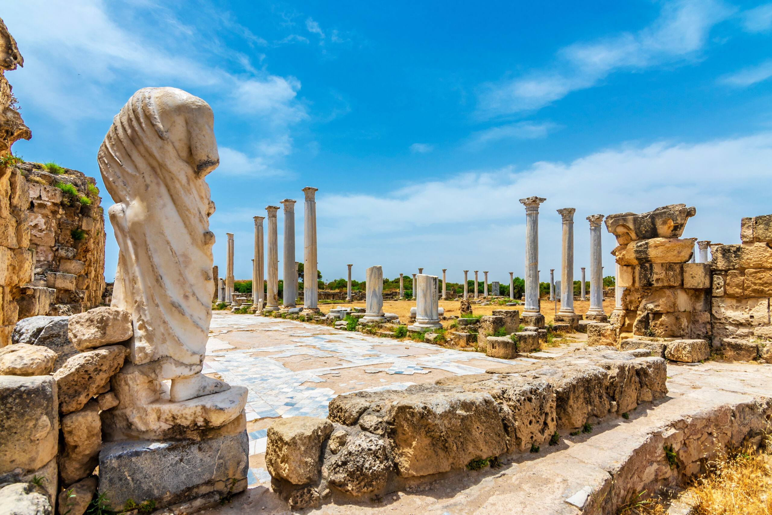 Ancient city with statues and pillars.