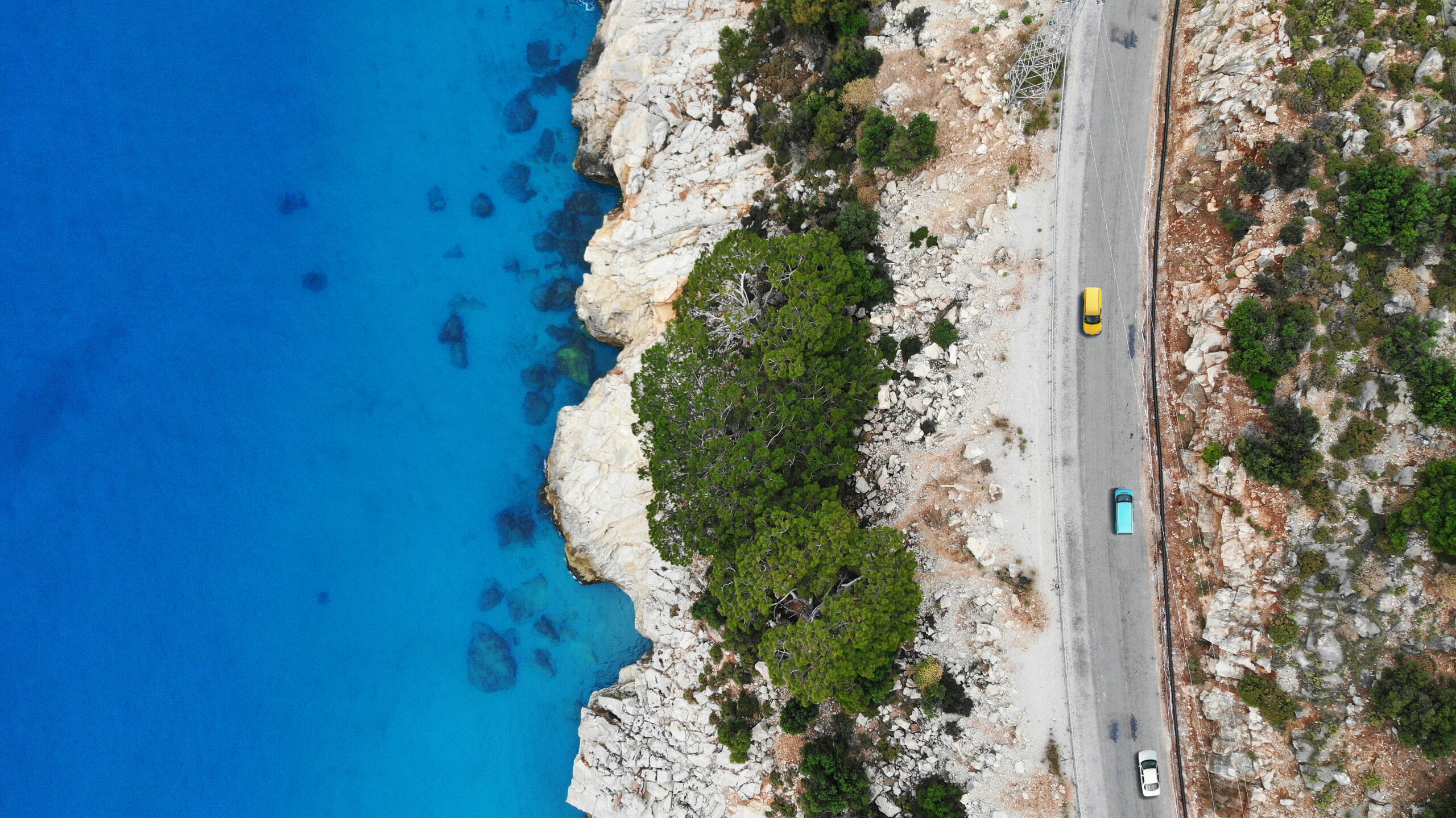 Cars driving by the highway near the mediterranean sea. Top view from drone.